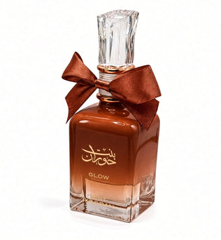 Bint Hooran Glow by Ard al Zaafaran Eau de Parfum 100ml – amber-brown gradient glass bottle with copper satin bow and clear faceted cap on white background